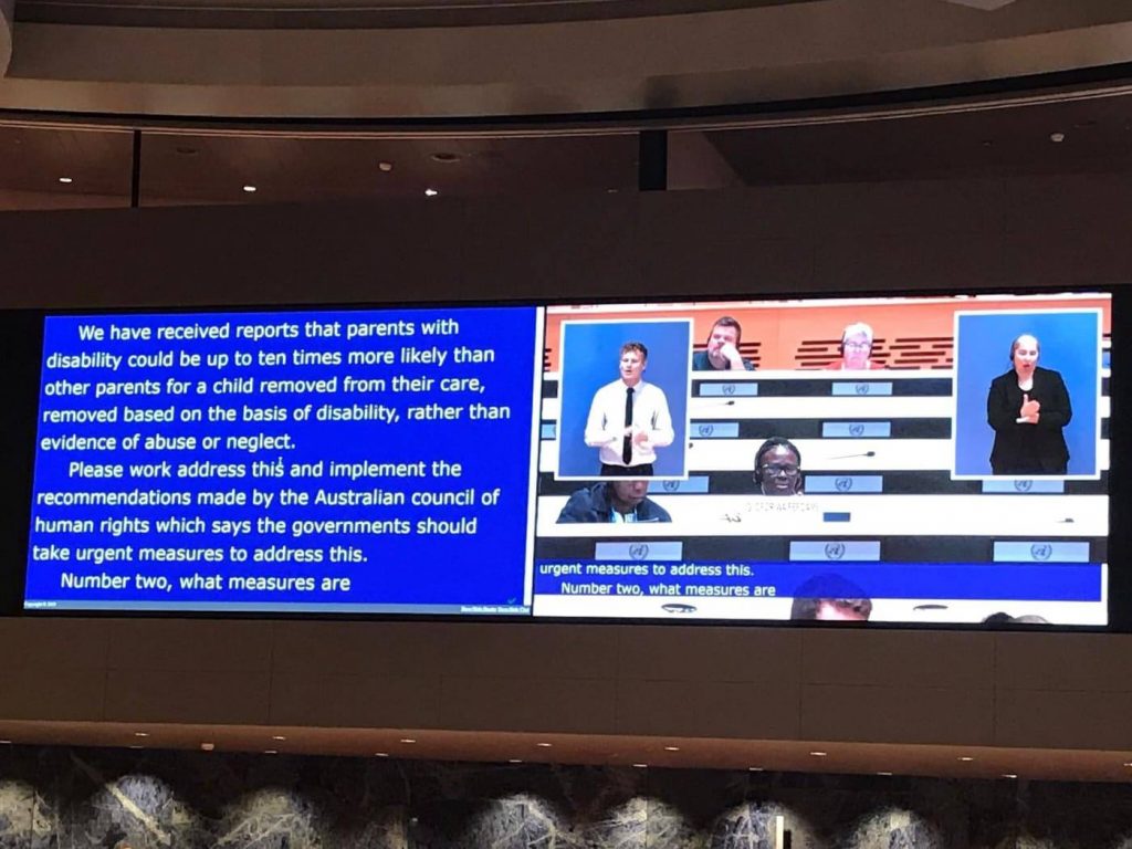 Photo of the projection screen from the UN session, showing interpreters and text captions.